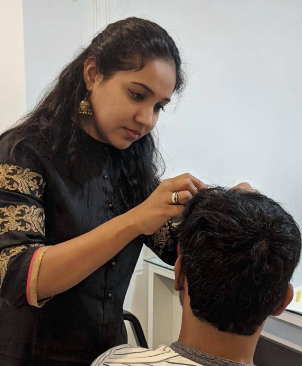 Dr Preethi Pellakuru examining a patient's scalp